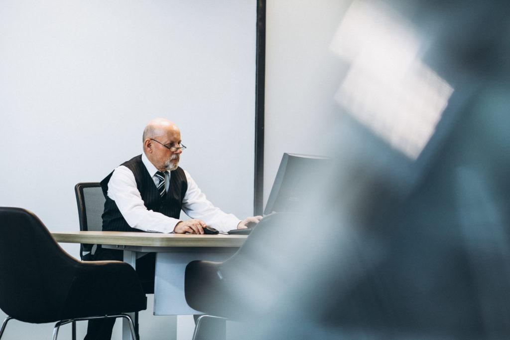 Manager senior travaillant sur ordinateur dans un bureau